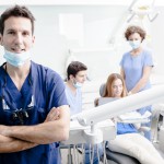 Dentists and assistants speaking with dental patient during dental checkup