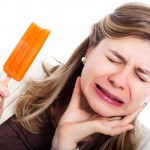 woman with sensitive teeth eating popsicle